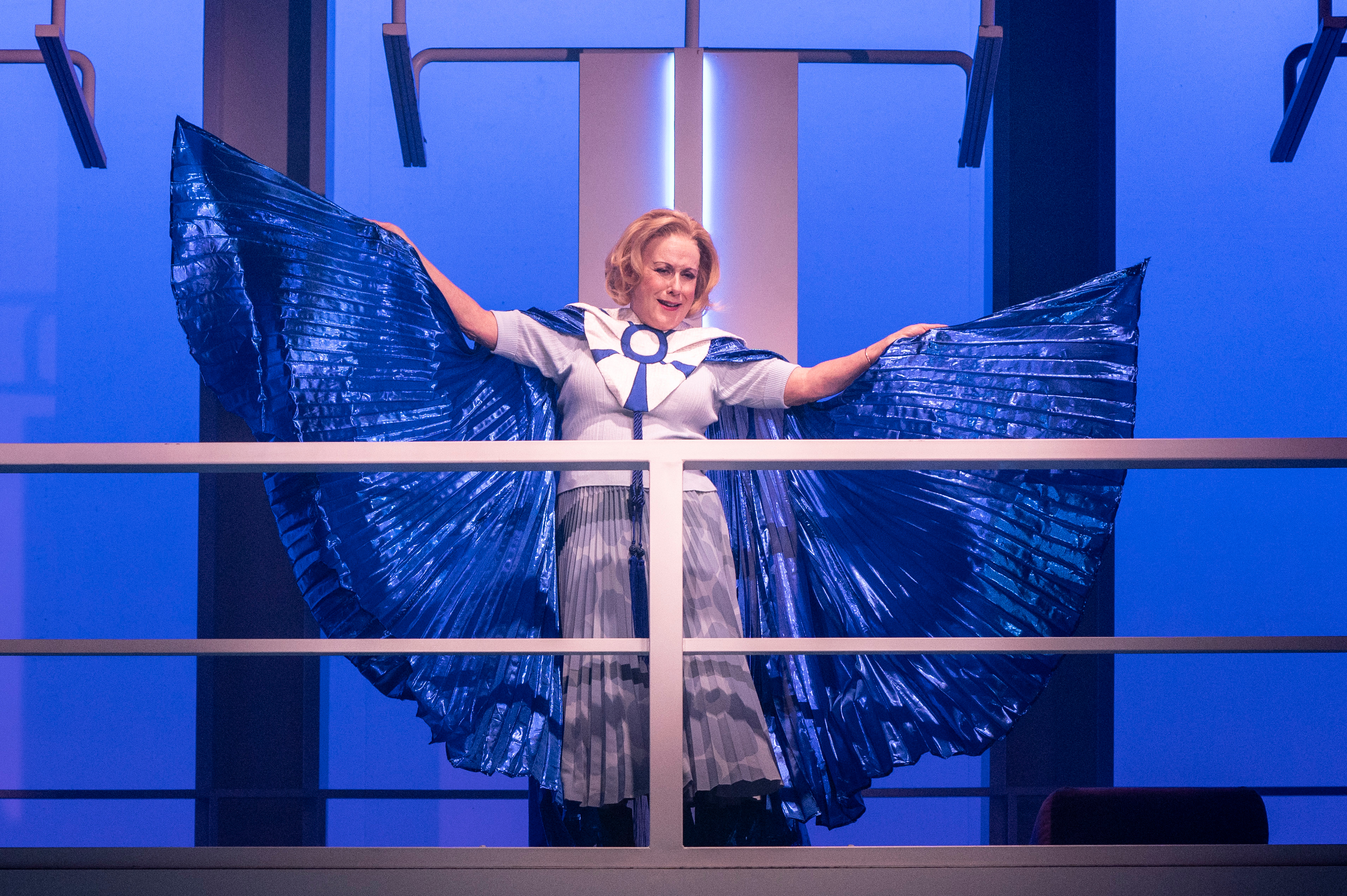 Judy Kaye on the upper balcony, spreading out a bright blue cape.